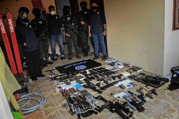 HASIL SERBUAN: Skuad antipengganasan Indonesia menunjukkan senjata api dan barangan yang dirampas dari rumah suspek di Bekasi, bersempadan dengan Jakarta, pada Isnin.