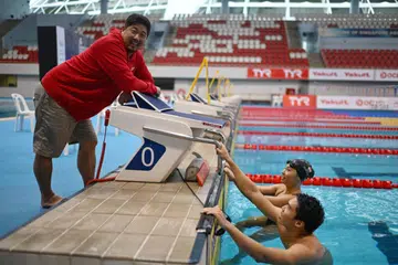BERI YANG TERBAIK: Jurulatih pasukan kebangsaan renang Singapura, Gary Tan (kiri), bersama perenang negara yang bakal ke Sukan Asia Hangzhou, Letitia Sim (tengah) dan Jonathan Tan. 