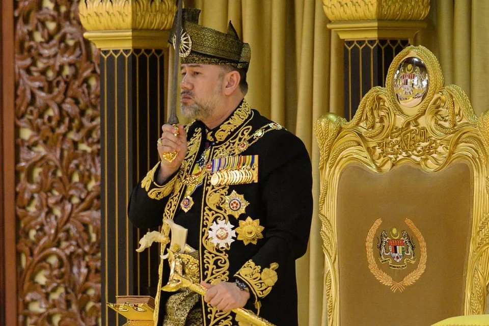 DITABAL: Sultan Muhammad V mencium keris semasa majlis pertabalan sebagai Yang di-Pertuan Agong ke-15 Malaysia di Istana Negara, semalam. - Foto AFP