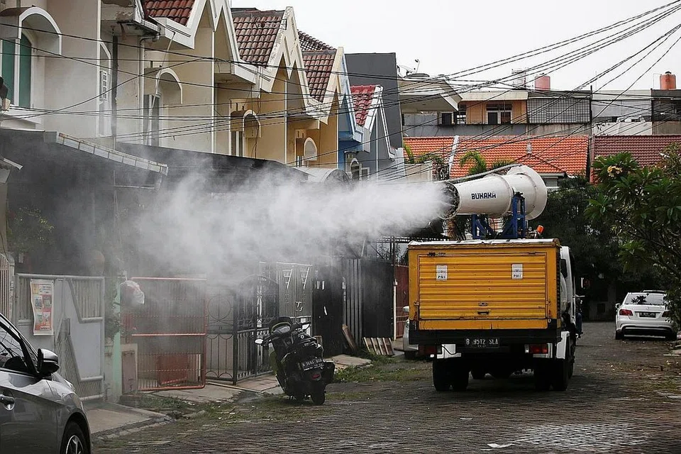 BENDUNG PENULARAN VIRUS: Palang Merah Indonesia sedang melakukan penyahjangkitan di sebuah kejiranan perumahan di Jakarta, sedang kes Covid-19 di Indonesia terus meningkat. - Foto REUTERS