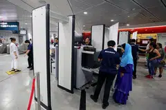 PERTINGKAT KESELAMATAN: Sebagai sebahagian daripada latihan persediaan kecemasan di Stesen MRT Holland Village (Laluan Circle) semalam, penumpang perlu melalui alat pengesanan pemeriksaan dan meletak barangan dalam sistem imbasan X-ray sebelum melepasi kawasan halangan tambang (faregate). - Foto ZAOBAO