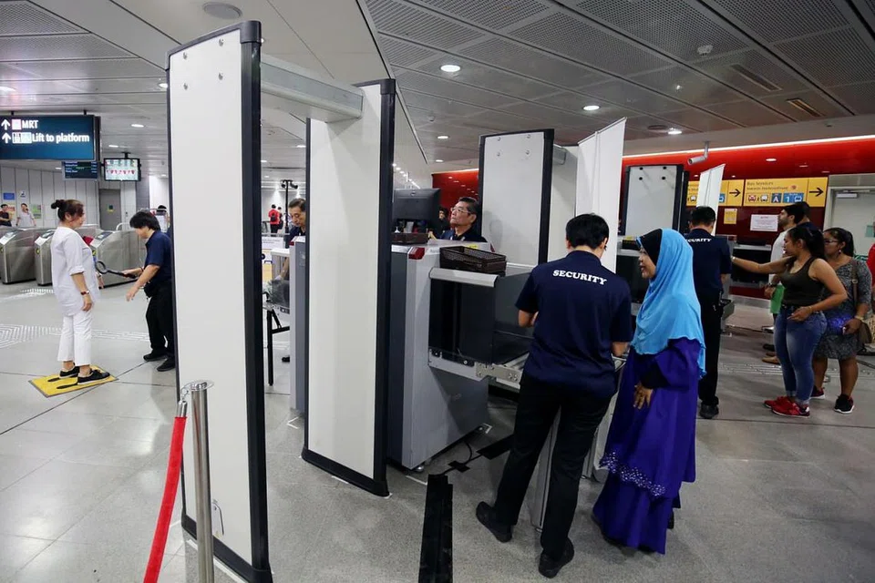 PERTINGKAT KESELAMATAN: Sebagai sebahagian daripada latihan persediaan kecemasan di Stesen MRT Holland Village (Laluan Circle) semalam, penumpang perlu melalui alat pengesanan pemeriksaan dan meletak barangan dalam sistem imbasan X-ray sebelum melepasi kawasan halangan tambang (faregate). - Foto ZAOBAO