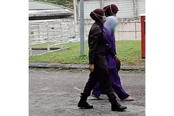 LIHAT KALI TERAKHIR: Pegawai penjara mengiringi ibu mangsa (tengah) untuk mengucapkan selamat tinggal terakhir kepada anaknya. - Foto NSTP