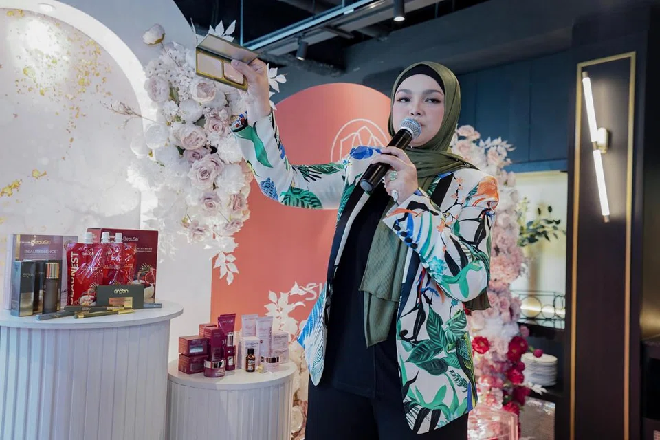 PRODUK KECANTIKAN: Datuk Siti menunjukkan salah satu produk kecantikan pada acara itu.