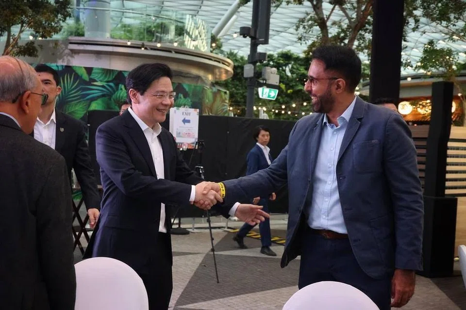 Perdana Menteri, Encik Lawrence Wong (dua dari kanan), dan Ketua Pembangkang, Encik Pritam Singh, bersalaman di majlis jamuan malam gala The Straits Times sempena ulang tahun ke-180 akhbar bahasa Inggeris itu di Jewel, Lapangan Terbang Changi pada 11 Julai.