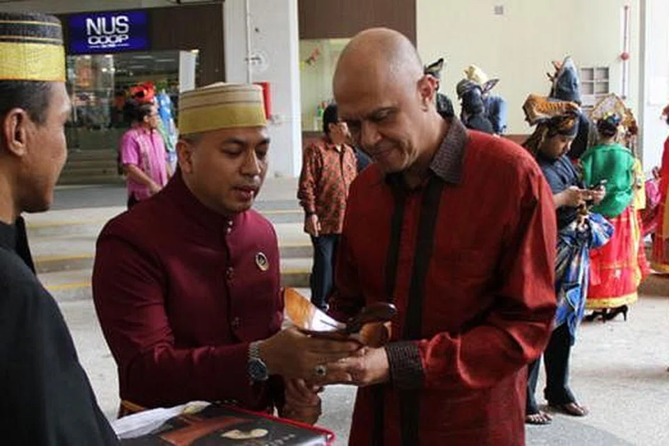 TERIMA HADIAH: Duta Besar Indonesia, Encik Andri Hadi (kanan) menerima hadiah daripada Encik Andi Mohamad Irvan Zulfikar, daripada Kelab Polobessi Bugis-Makassar sempena Pameran 'Logam' yang menampilkan keris Bugis Makassar di Perpustakaan Pusat Universiti Nasional Singapura. Pameran berakhir hari ini. - Foto ihsan JABATAN PENGAJIAN ASIA TENGGARA NUS