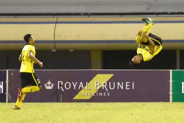LONCATAN KEGEMBIRAAN: Pemain Balestier, Huzaifah Aziz (kanan) meraikan gol penyamaan dengan satu lompatan akrobatik semasa membantu pasukannya seri 2-2 dengan Brunei DPMM. - Foto ZAINAL YAHYA
