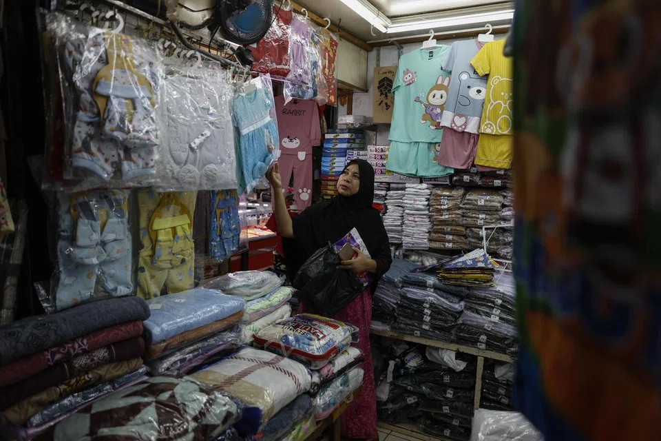 Seorang pelanggan di sebuah pasar di Jakarta, Indonesia, pada 2 Disember sedang pemerintah Indonesia mengumumkan akan mengenakan kenaikan kadar cukai nilai tambah (VAT) kepada 12 peratus hanya tertumpu kepada barangan mewah bagi mengelakkan kesan terhadap kuasa daya beli masyarakat berpendapatan rendah.
