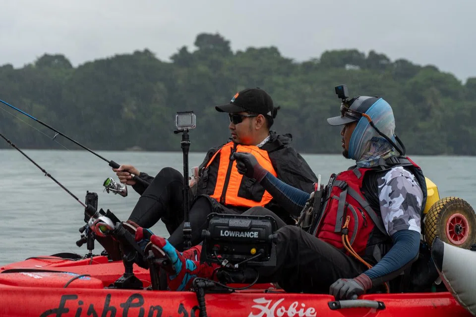 Wartawan BM, Muhd Hazman Abd Aziz (kiri), mendapat tunjuk ajar dari pemancing kayak, Encik Nordin Kasmuri, mengenai cara memancing ikan menggunakan kayak. 