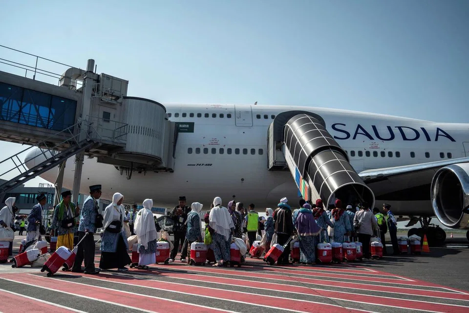 BERSIAP UNTUK BERANGKAT: Jemaah haji Indonesian beratur untuk menaiki sebuah pesawat yang akan membawa mereka ke Makkah dari Lapangan Terbang Antarabangsa Juanda di Sidoarjo pada 24 Mei. 