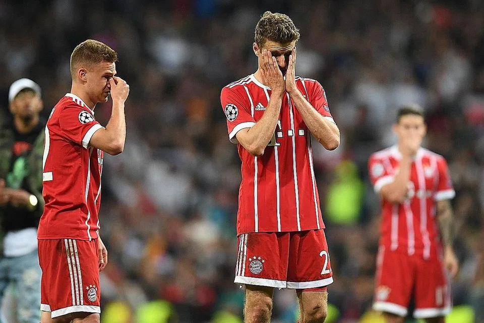 Pemain midfield Bayern Joshua Kimmich (kiri) dan bintang penyerang Jerman, Thomas Mueller (tengah) kecewa di akhir pertarungan dengan Real. - Foto AFP