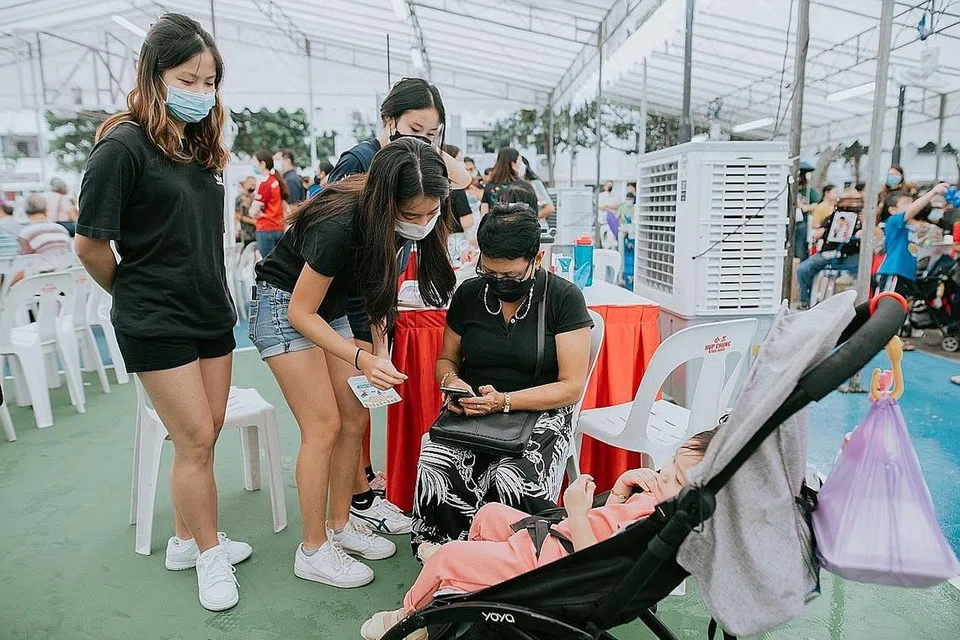 PELANCARAN APLIKASI: Para relawan sedang beri panduan dan mengajar cara menggunakan aplikasi MacPherson Cares. - Foto MACPHERSON CONSTITUENCY OFFICE
