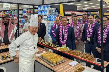 Duta Singapura, Encik Premjith Sadasivan (tengah), mencuba hidangan yang disediakan oleh cef Singapura, Cef Justin Quek (kiri). 