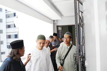 Encik Hanif Abdul Rahman (dua dari kiri), menantu Allahyarham Rahmat Mawar, menerima salam takziah daripada mereka yang melawat jenazah di Blok 469, Segar Road pada 29 Oktober.
