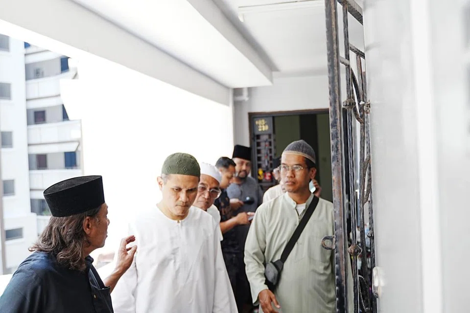 Encik Hanif Abdul Rahman (dua dari kiri), menantu Allahyarham Rahmat Mawar, menerima salam takziah daripada mereka yang melawat jenazah di Blok 469, Segar Road pada 29 Oktober.