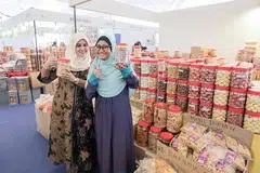 KUIH RAYA BUATAN TANGAN: Cik Zarina (kiri) bersama rakan sekerja yang mengendalikan gerai Warung Man Baba di Bazar Raya Utara. - Foto BH oleh IQBAL FAISAL
