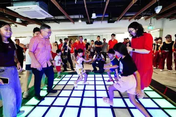 Timbalan Perdana Menteri (DPM) Encik Gan Kim Yong (dua dari kiri) dan Anggota Parlimen (AP) GRC East Coast, Cik Hazlina Abdul Halim (kanan) menyertai kanak-kanak dalam permainan “Floor Is Lava” di Kelab Masyarakat Fengshan pada 26 April.