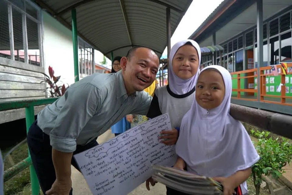 TUMPUAN PENDIDIKAN: Mantan menteri pendidikan Malaysia, Dr Mazlee Malik, mengadakan lawatan ke Sekolah Kebangsaan Abang Man di Simunjan, Sarawak, pada September lalu dan bergambar bersama dua anak murid bernama Damia dan Azwa. - Foto ihsan MASZLEE MALIK