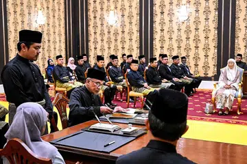 PROSES ANGKAT SUMPAH: Datuk Seri Anwar (duduk, dua dari kiri) menandatangani beberapa dokumen yang mengesahkan pelantikannya selaku Perdana Menteri Malaysia ke-10. - Foto AFP
