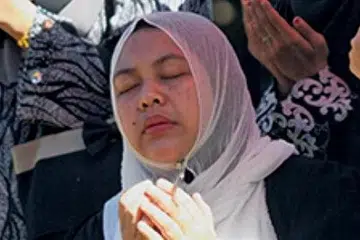 REDA ATAS PEMERGIAN: Cik Nor Azlina berdoa selepas jenazah anaknya, Allahyarhamha Nursyuhada, selamat dikebumikan di Kampung Cherok Mokkan, Kubang Pasu, Kedah. - Foto UTUSAN MALAYSIA