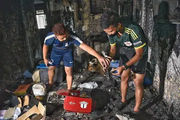MUSNAH: (Gambar atas) Encik Muhammad Huzaimi Zuraimi, 22 tahun dan abangnya, Encik Muhammad Haiqal Zuraimi, 23 cuba cari barangan yang boleh diselamatkan setelah flat dua bilik mereka di Whampoa musnah. - Foto BH oleh DESMOND WEE