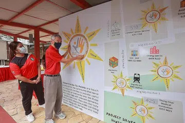 PEKA TENTANG KEPERLUAN WARGA EMAS: Anggota Parlimen GRC Ang Mo Kio, Cik Nadia Ahmad Samdin (kiri) dan aktivis akar umbinya mengenalkan inisiatif rangkaian jagaan Care Network-Living Well di kejiranan Cheng San-Seletar yang dilancarkan Perdana Menteri Lee Hsien Loong bagi melengkapi masyarakat dengan kemahiran menangani isu kesihatan mental warga emas. - Foto ZAOBAO