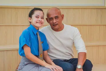 KONGSI KEJAYAAN: Alea berkata keluarganya termasuk bapanya, Encik Osman Hassan (di sebelahnya), banyak berkorban masa, tenaga dan wang ringgit untuk memastikan beliau dapat terus bangkit dengan semangat baru selepas menjalani dua pembedahan. - Foto BH oleh NUR DIYANA TAHA