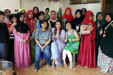 TURUN PADANG DI MUSIM LEBARAN: Anggota baru Lembaga Pengarah Pertubuhan Kemanusiaan Bagi Ekonomi Buruh Hijrahan (H.O.M.E), Cik Linda Ma'arof (duduk di tengah, berbaju kurung ungu), bersama Pengarah Pentadbiran H.O.M.E, Cik Sisi Sukiato (duduk di kanan), dan Pengarah Kewangan dan Operasi H.O.M.E, Cik Dominica Fitri Masniari (duduk di kiri), meraikan 1 Syawal bersama pembantu rumah Indonesia di bawah jagaan mereka. - Foto ihsan LINDA MA'AROF