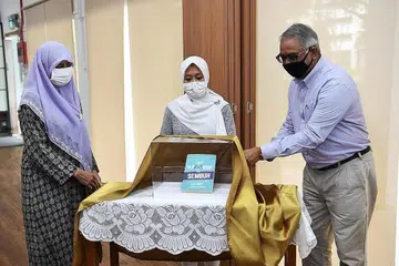 BUKU ATASI KETAGIHAN: (Dari kiri) Dr Radiah Salim, Cik Rahayu Mahzam dan Encik Ram Dubey melancarkan buku 'Dari Kambuh ke Sembuh' di majlis pembukaan semula pusat Kelab Heal di Bukit Batok East, semalam.- Foto BH oleh KHALID BABA