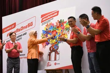 LANCAR KEMPEN: Presiden Halimah Yacob menampal pelekat berbentuk bunga semasa majlis pelancaran kempen sukarela NDP 2023, #GiveAsOneSG di Kelab Masyarakat Chua Chu Kang pada Rabu.