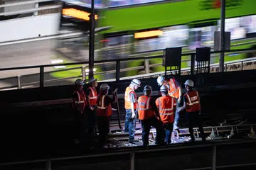 Para pekerja menjalankan kerja-kerja pembaikan di bahagian landasan yang rosak berhampiran Depoh Ulu Pandan pada 11.30 malam, 26 September. SMRT menyasarkan untuk memulihkan perkhidmatan kereta api sepenuhnya pada 30 September.