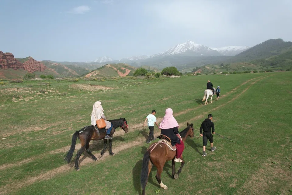 Dr Mumtaz (kanan) menunggang kuda di Kyrgyzstan bersama rakan-rakannya.