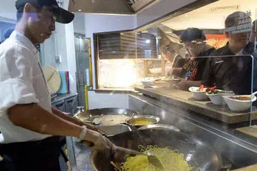 PANAS-PANAS: Mi Hokkien digoreng panas di kaunter masak secara langsung membuka selera pelanggan dekat pintu masuk Sakura International Buffet Yio Chu Kang yang menjalani pengubahsuaian konsep dan menu. - Foto-foto TAUFIK A. KADER