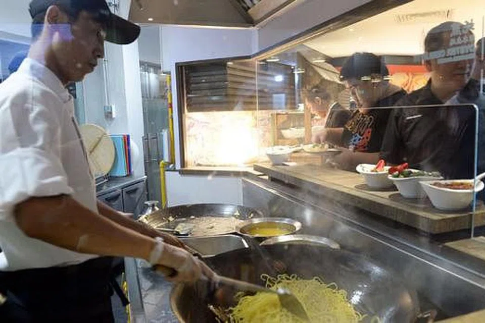 PANAS-PANAS: Mi Hokkien digoreng panas di kaunter masak secara langsung membuka selera pelanggan dekat pintu masuk Sakura International Buffet Yio Chu Kang yang menjalani pengubahsuaian konsep dan menu. - Foto-foto TAUFIK A. KADER