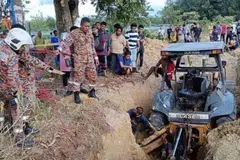 Anggota Jabatan Bomba dan Penyelamat (JBPM) membantu menggali perigi yang tertimbus tanah untuk mencari mangsa di Kampung Gelam Tok Uban, Pasir Mas, Kelantan, pada petang 15 April.