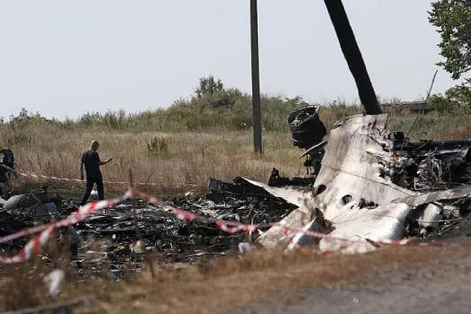 SIASATAN BERMULA DI TAPAK KEJADIAN: Seorang penyiasat nahas pesawat dari Malaysia memeriksa bangkai pesawat MH17 dekat kampung Hrabove (Grabovo) di Donetsk. - Foto REUTERS