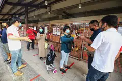 IMBAS KAD PENGENALAN: Pengunjung ke Pasar Geylang Serai perlu mengimbas kad pengenalan mereka sebagai sebahagian langkah 'SafeEntry' bagi tujuan menjejak kontak. - Foto fail