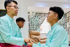 (kiri) Encik Khairulddin Yatim bersalaman dan bermaafan dengan anaknya, Afzal Khairulddin (kanan) manakala seorang lagi anaknya, Afraz duduk bersebelahan beliau di sofa.