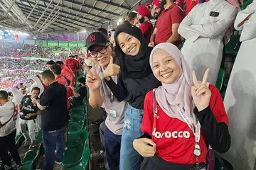 PENGALAMAN UNIK: Encik Zamree (kiri) bersama anaknya, Cik Nasyitha (tengah) dan Cik Nadiah ketika menonton perlawanan Maghribi lawan Sepanyol. - Foto ihsan ZAMREE MUSTAPHA
