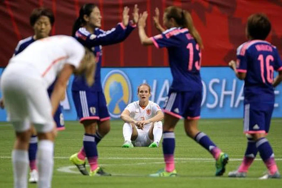 WAJAH GEMBIRA DAN LUKA: Para pemain Jepun (jersi biru) meraikan kejayaan melangkah ke suku akhir Piala Dunia Wanita sedang pemain Belanda, Desiree Van Lunteren (tengah), terduduk kecewa. - Foto REUTERS