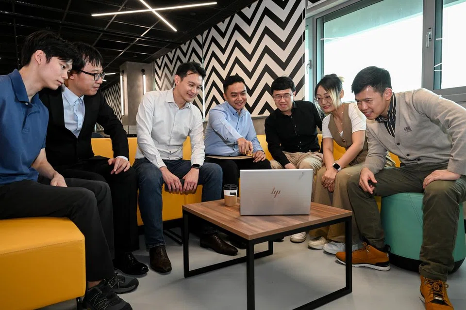 Encik Hamzah Kamaruddin (empat dari kiri) bersama pasukan serta mentor pasukannya, Naib Presiden bagi Teknologi Baru Muncul di Temasek, Dr Daniel Tay (tiga dari kiri).