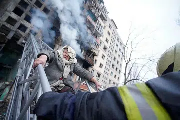 SELAMATKAN MANGSA SERANGAN: Penyelamat sedang membantu seorang wanita tua keluar daripada tempat kediamannya selepas bangunan yang dihuninya di Kyiv dibedil tentera Russia. - Foto REUTERS