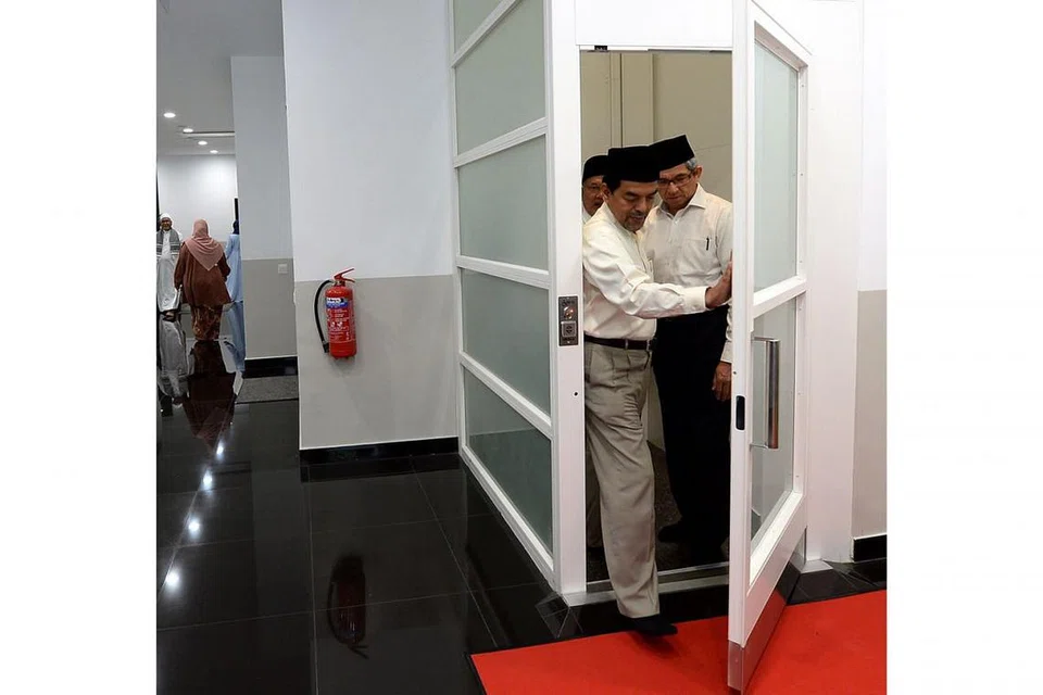 UMPAMA PINTU BILIK: Sekali pandang ia kelihatan tidak ubah seperti sebuah bilik. Sebenarnya ini adalah pintu menaiki lif iaitu satu kemudahan terkini yang diperkenalkan di Masjid Al-Falah bagi mempermudah jemaah kurang upaya dan berkerusi roda untuk naik ke aras kedua. Kelihatan (dari hadapan) Ketua Eksekutif Muis, Haji Abdul Razak Hassan Maricar; Menteri Bertanggungjawab bagi Ehwal Masyarakat Islam, Dr Yaacob Ibrahim; dan Pengerusi Eksekutif Masjid Al-Falah, Haji Yahya Hashim.