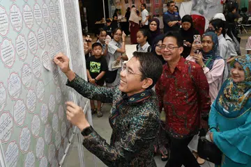 PAPARAN PANTUN ASLI MELAYU TERBESAR: Menteri di Pejabat Perdana Menteri yang juga Menteri Kedua (Ehwal Luar merangkap Pendidikan), Dr Mohamad Maliki Osman, yang juga pengerusi Pembelajaran dan Penggalakan Penggunaan Bahasa Melayu, melekatkan pantun ditulisnya di dinding di Fiesta Bahasa 2023 pada Sabtu, acara yang mencatatkan rekod bagi ‘Paparan Pantun Melayu Asli Terbesar’ di dalam Buku Rekod Singapura.