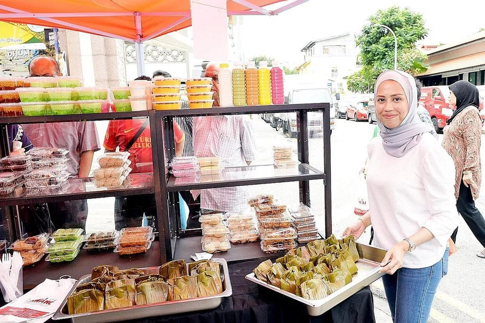 MENGEKALKAN RASA ASLI: Cik Nur Syahidah Mohd Zin sekeluarga tetap menggunakan resipi asli daripada neneknya bagi mengekalkan rasa asli kuih-muih tradisional yang dijual di Rumah Makan Minang. - Foto BH oleh KHALID BABA 