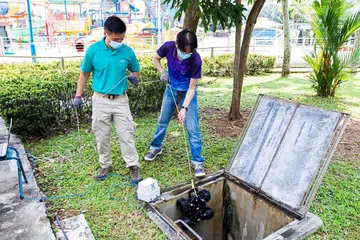 DEMI KESELAMATAN: Pegawai SecCom sedang menurunkan Kenderaan Kawalan Jauh (RCV) ke dalam sebuah longkang untuk memastikan tiada bahan atau barang letupan tersembunyi yang boleh mengancam keselamatan VVIP dan orang sekeliling. - Foto PASUKAN POLIS SINGAPURA (SPF)