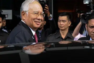 Perdana Menteri Malaysia, Datuk Seri Najib Razak, tersenyum kepada jurugambar selepas menghadiri sesi parlimen di Kuala Lumpur pada Selasa, 26 Januari. Gambar AFP