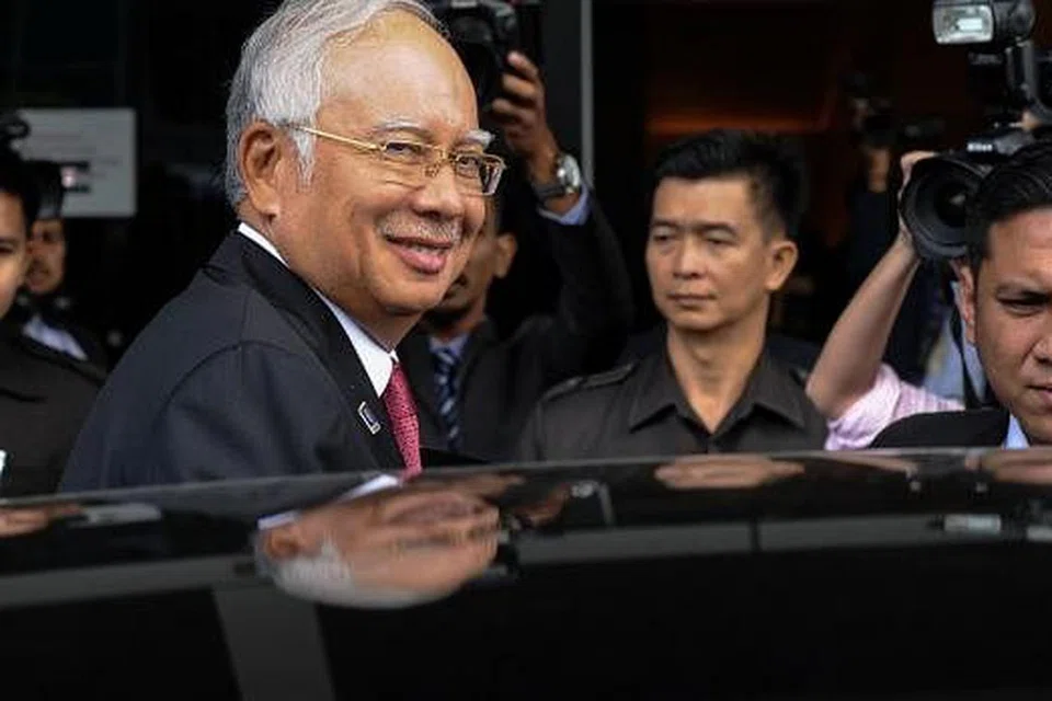Perdana Menteri Malaysia, Datuk Seri Najib Razak, tersenyum kepada jurugambar selepas menghadiri sesi parlimen di Kuala Lumpur pada Selasa, 26 Januari. Gambar AFP