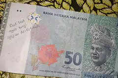 Seorang lelaki di Malaysia menerima wang ringgit RM50 dengan tulisan nota selepas beliau keluarkannya dari mesin ATM di sebuah kios minyak.