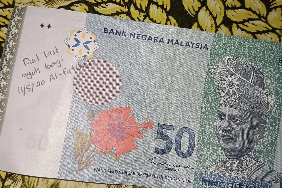 Seorang lelaki di Malaysia menerima wang ringgit RM50 dengan tulisan nota selepas beliau keluarkannya dari mesin ATM di sebuah kios minyak.